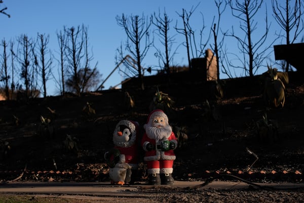 Christmas decorations are left standing in a fire-ravaged community in the aftermath of the Palisades Fire in the Pacific Palisades neighborhood of Los Angeles, Monday, Jan. 13, 2025. (AP Photo/John Locher)