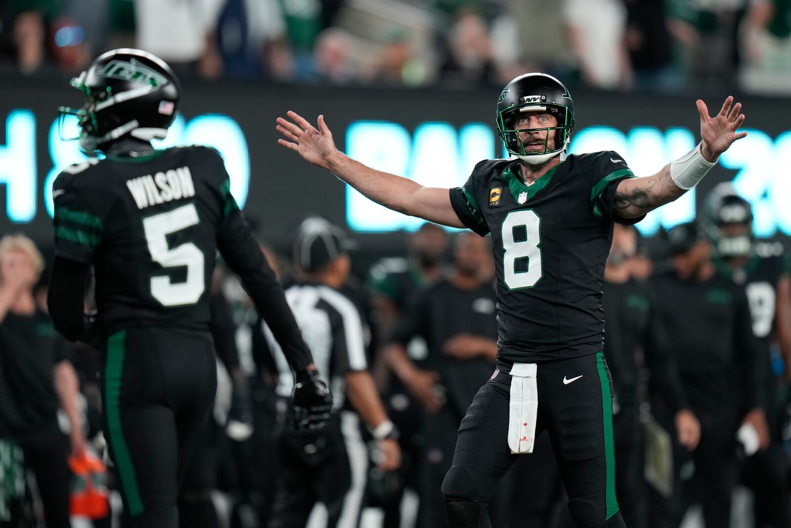 New York Jets quarterback Aaron Rodgers (8) celebrates as officials review a catch by wide receiver Garrett Wilson (5) during the second half of an NFL football game against the Houston Texans, Thursday, Oct. 31, 2024, in East Rutherford, N.J. (AP Photo/Seth Wenig)