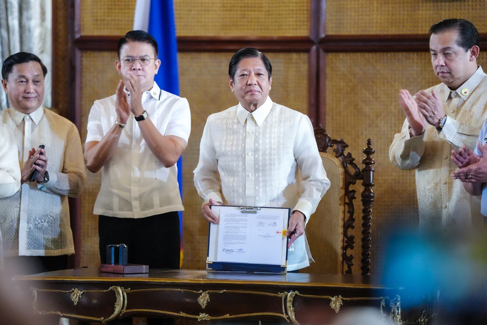 In this photo provided by the Malacanang Presidential Communications Office, Philippine President Ferdinand Marcos Jr., second from right, shows a document beside Senate President Francis Escudero, second from left, and House Speaker Martin Romualdez during the ceremonial signing of the Philippine Maritime Zones and Philippine Archipelagic Sea Lanes Act at the Malacanang presidential palace in Manila, Philippines on Friday, Nov. 8, 2024. (Malacanang Presidential Communications Office via AP)