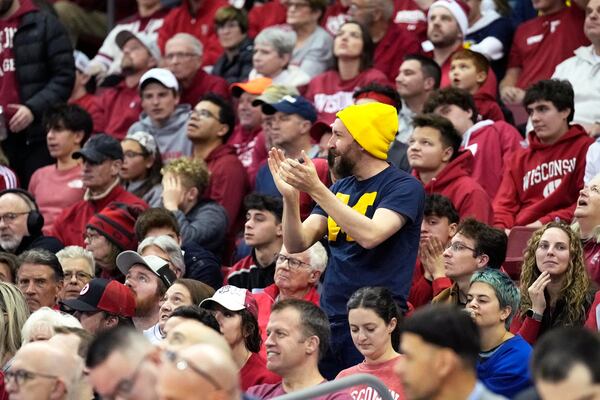 A Michigan fan cheers as the Wolverines take the lead during the second half of an NCAA college basketball game against Michigan Tuesday, Dec. 3, 2024, in Madison, Wis. Michigan won 67-64. (AP Photo/Kayla Wolf)