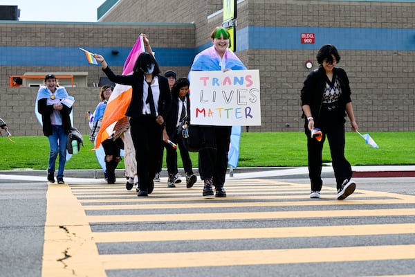 FILE - Students carrying pride and transgender flags leave Great Oak High School in Temecula, Calif., Friday, Sept. 22, 2023, after walking out of the school in protest of the Temecula school district policy requiring parents to be notified if their child identifies as transgender. (Anjali Sharif-Paul/The Orange County Register via AP, File)