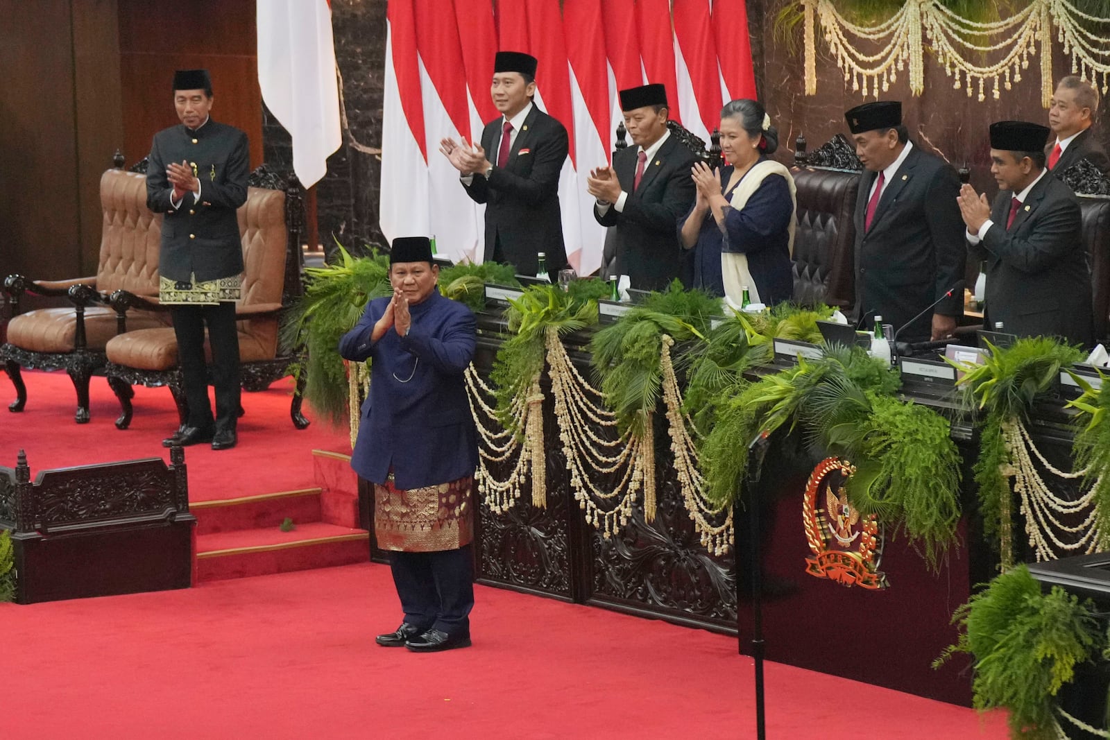 Newly-inaugurated Indonesian President Prabowo Subianto, center, reacts as his predecessor Joko Widodo, left, and leaders of the People's Consultative Assembly applaud after Subianto was sworn in as the country's eighth president in at the parliament building in Jakarta, Indonesia, Sunday, Oct. 20, 2024. (AP Photo/Tatan Syuflana)