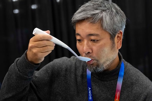 Kiyohiro Izumo uses the Kirin Electric Salt spoon which intensifies salt flavor by flowing a mild electric current through the food around the tongue to attract salt towards the tongue, during 2025 CES Unveiled, Sunday, Jan. 5, 2025, in Las Vegas. (AP Photo/Jack Dempsey)