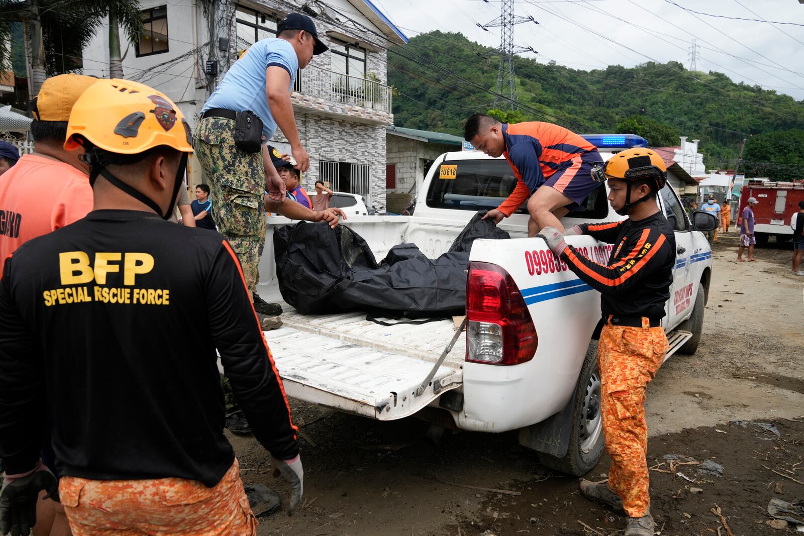 A body is recovered by rescuers after a recent landslide triggered by Tropical Storm Trami struck Talisay, Batangas province, Philippines which thousands homeless and several villagers dead on Saturday, Oct. 26, 2024. (AP Photo/Aaron Favila)