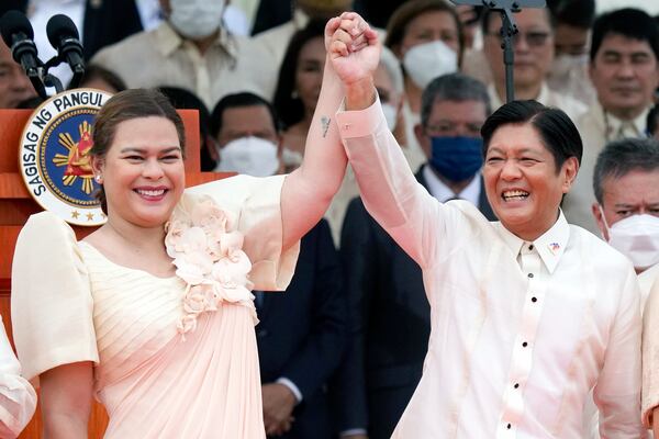 FILE - Philippine President Ferdinand Marcos Jr., center right, and Vice President Sara Duterte, daughter of former Philippine President Rodrigo Duterte, raise hands during the inauguration ceremony at National Museum on Thursday, June 30, 2022 in Manila, Philippines. (AP Photo/Aaron Favila, File)