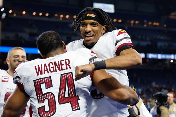 Washington Commanders quarterback Jayden Daniels celebrates with Bobby Wagner (54) after an NFL football divisional playoff game against the Detroit Lions, Saturday, Jan. 18, 2025, in Detroit. (AP Photo/Rey Del Rio)