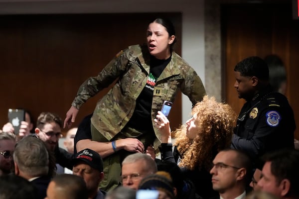 A protestor is removed during a Senate Armed Services Committee confirmation hearing for Pete Hegseth, President-elect Donald Trump's choice to be Defense secretary, at the Capitol in Washington, Tuesday, Jan. 14, 2025. (AP Photo/Ben Curtis)