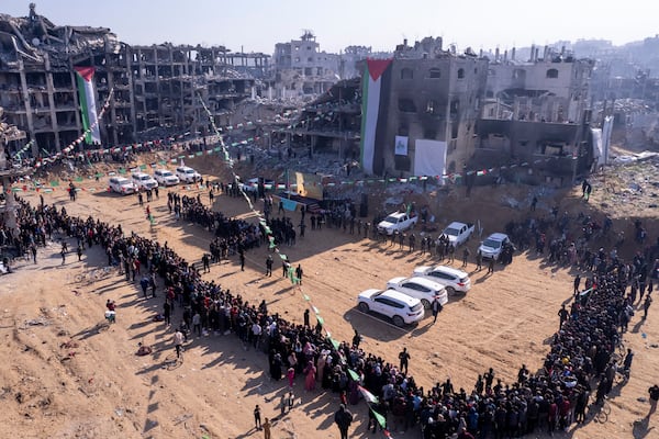 Red Cross vehicles, left, wait for the hand-over of Israeli soldier hostage Agam Bergerat the Jabalya refugee camp in Gaza City, Thursday Jan. 30, 2025.(AP Photo/Mohammad Abu Samra)