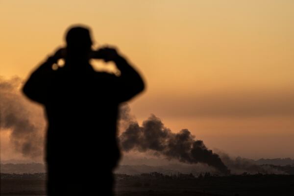 A man looks at smoke rising following an explosion inside the Gaza Strip, from an observation point in Sderot, southern Israel, Monday, Jan. 13, 2025. (AP Photo/Ariel Schalit)