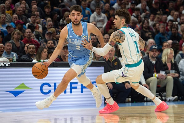 Cleveland Cavaliers' Ty Jerome (2) drives around Charlotte Hornets' LaMelo Ball (1) during the first half of an NBA basketball game in Cleveland, Sunday, Nov 17, 2024. (AP Photo/Phil Long)