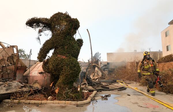 FILE - A firefighter walks past a charred bunny sculpture and debris at the destroyed Bunny Museum, Thursday, Jan. 9, 2025, in Altadena, Calif. (AP Photo/Chris Pizzello, File)