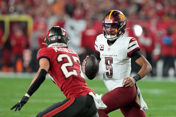 Washington Commanders quarterback Jayden Daniels (5) runs against Tampa Bay Buccaneers cornerback Zyon McCollum (27) during the first half of an NFL wild-card playoff football game in Tampa, Fla., Sunday, Jan. 12, 2025. (AP Photo/Chris O'Meara)