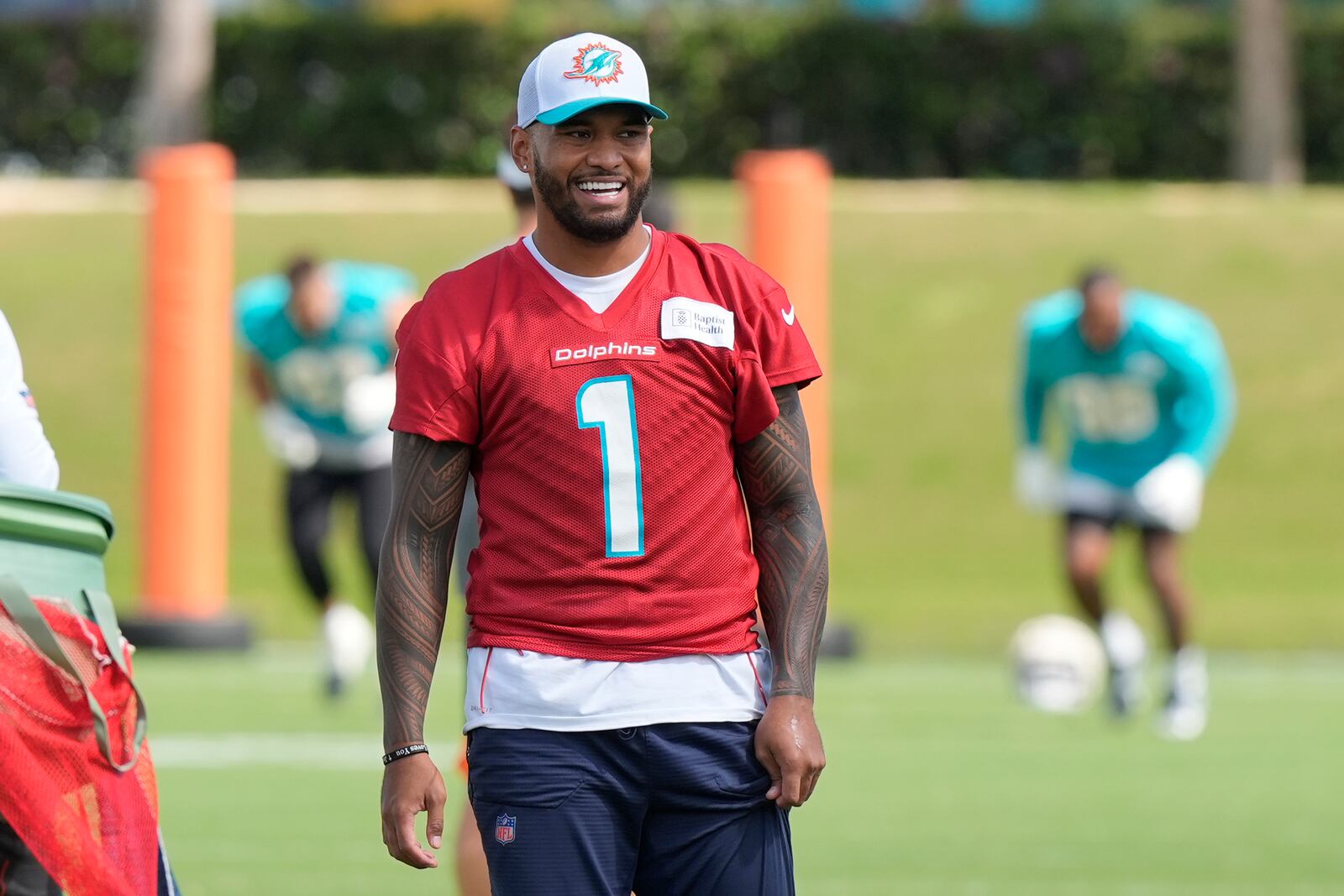 Miami Dolphins quarterback Tua Tagovailoa (1) smiles during a practice session at the team's training facility, Wednesday, Oct. 23, 2024, in Miami Gardens, Fla. (AP Photo/Marta Lavandier)