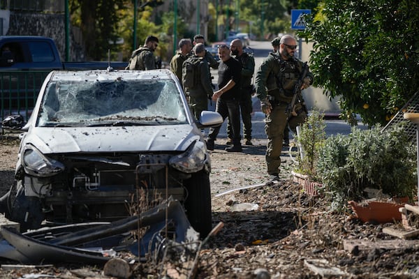 Israeli security officers and army soldiers inspect the site where a rocket fired from Lebanon landed in a backyard in Kiryat Shmona, northern Israel, Tuesday Nov. 26, 2024. (AP Photo/Leo Correa)