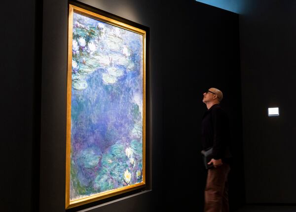 FILE - A man looks at "Nympheas," by Claude Monet, during an auction preview at Sotheby's in New York, Monday, Nov. 11, 2024. (AP Photo/Eduardo Munoz Alvarez)