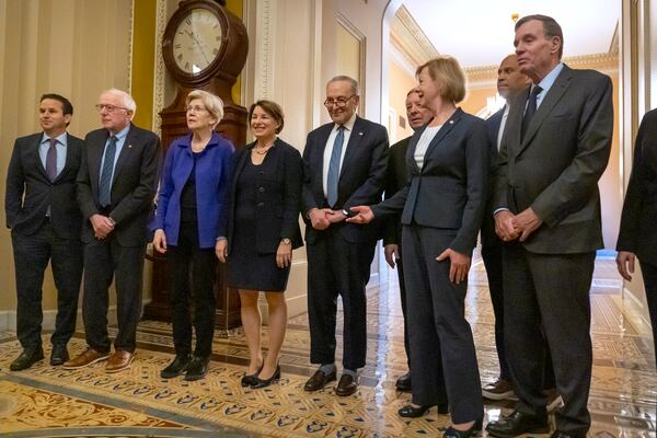 Senators, from left, Sen. Brian Schatz, D-Hawaii, Sen. Bernie Sanders, I-Vt., Sen. Elizabeth Warren, D-Mass., Sen. Amy Klobuchar, D-Minn., Senate Majority Leader Chuck Schumer of N.Y., Sen. Dick Durbin, D-Ill., Sen. Tammy Baldwin, D-Wis., Sen. Cory Booker, D-N.J., and Sen. Mark Warner, D-Va., gather after Senate Democratic leadership elections for the next session of Congress on Capitol Hill, Tuesday, Dec. 3, 2024, in Washington. (AP Photo/Mark Schiefelbein)