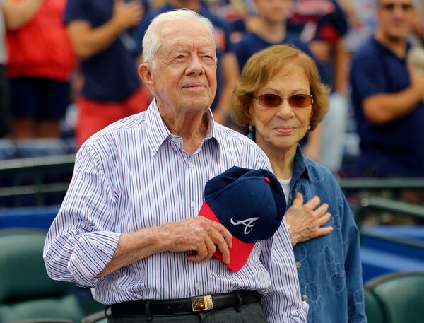 FILE - Former President Jimmy Carter and his wife, Rosalynn, stand for the national anthem before a baseball game between the Atlanta Braves and the San Diego Padres, June 10, 2015, in Atlanta. (AP Photo/John Bazemore, File)