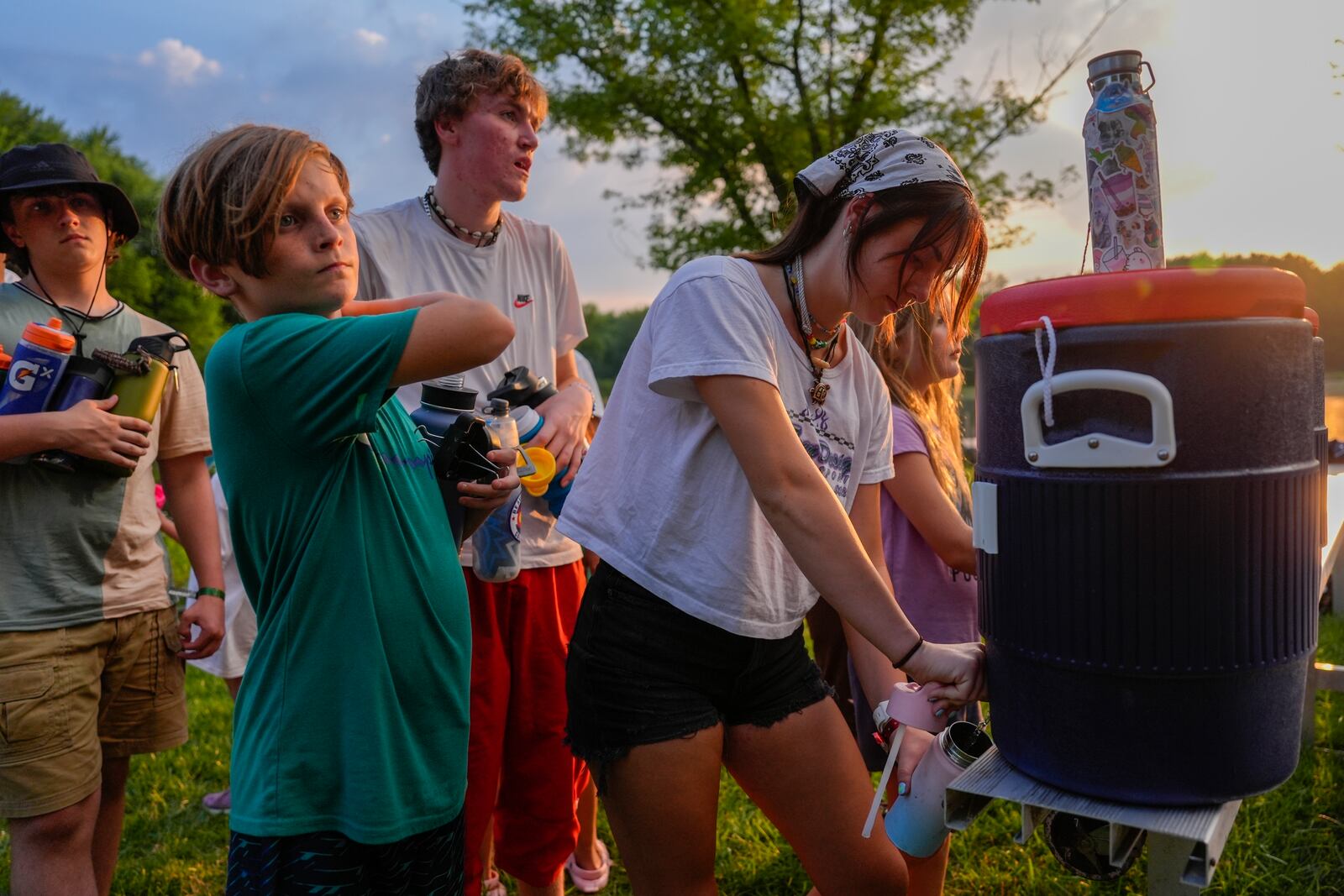 FILE - Counselor Izzy Kellar, of Dayton, Ohio, fills up her campers' water bottles, June 20, 2024, at YMCA Camp Kern in Oregonia, Ohio. (AP Photo/Joshua A. Bickel)