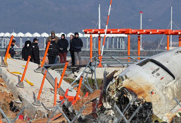 Experts from the U.S. National Transportation Safety Board (NTSB) and joint investigation team between the U.S. and South Korea check the site of a plane crash at Muan International Airport in Muan, South Korea, Tuesday, Dec. 31, 2024. (Son Hyung-joo/Yonhap via AP)