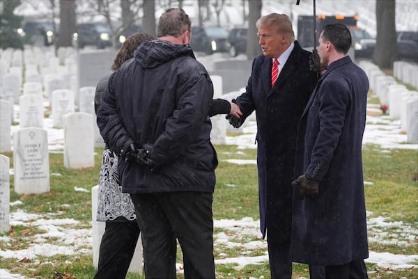 President-elect Donald Trump talks with family members in Section 60 at Arlington National Cemetery, Sunday, Jan. 19, 2025, in Arlington, Va. (AP Photo/Evan Vucci)