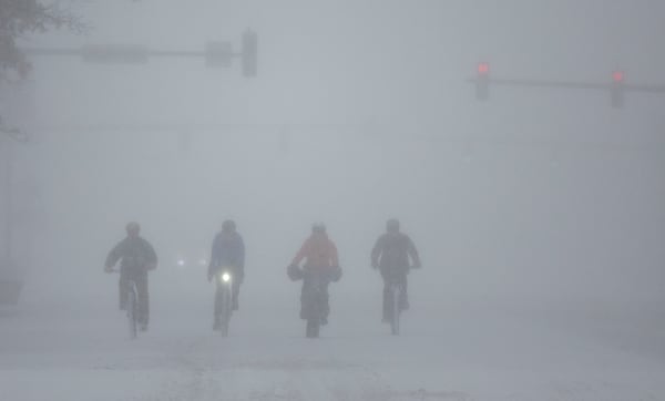 A group of cyclists make way through downtown Wichita, Kan., during a severe winter storm on Sunday, Jan. 5, 2024 (Travis Heying/The Wichita Eagle via AP)