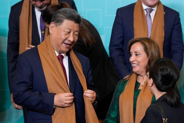 China's President Xi Jinping, left, speaks with Peru's President Dina Boluarte, right, as they and other APEC leaders gather for a family photograph at the APEC Summit in Lima, Peru on Saturday, Nov. 16, 2024. (AP Photo/Manuel Balce Ceneta)