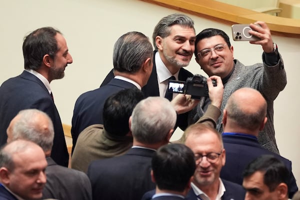 Georgian president-elect Mikheil Kavelashvili, 2nd right, poses for a selfie at the Georgian parliament, in Tbilisi, Georgia, Saturday. Dec. 14, 2024. (AP Photo)