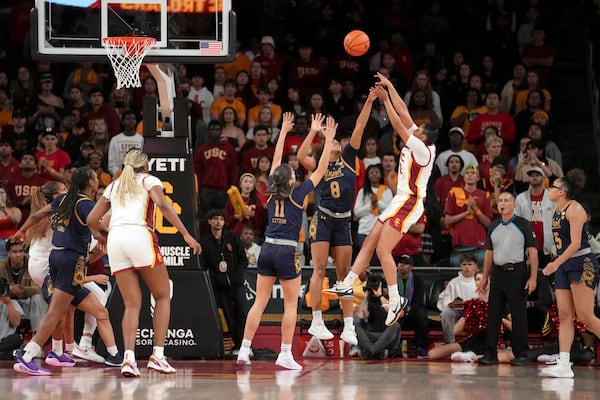 Southern California guard JuJu Watkins (12) shoots over Notre Dame guards Cassandre Prosper (8) and Sonia Citron (11) during the first half of an NCAA college basketball game, Saturday, Nov. 23, 2024 in Los Angeles. (AP Photo/Eric Thayer)