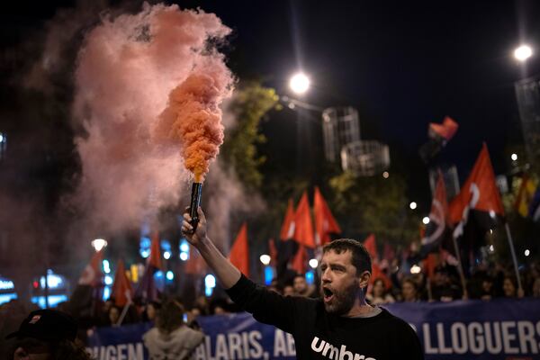 Demonstrators light flares while march in a protest against the exorbitant rise in the price of renting an apartment in Barcelona, Spain, Saturday, Nov. 23, 2024. (AP Photo/Emilio Morenatti)