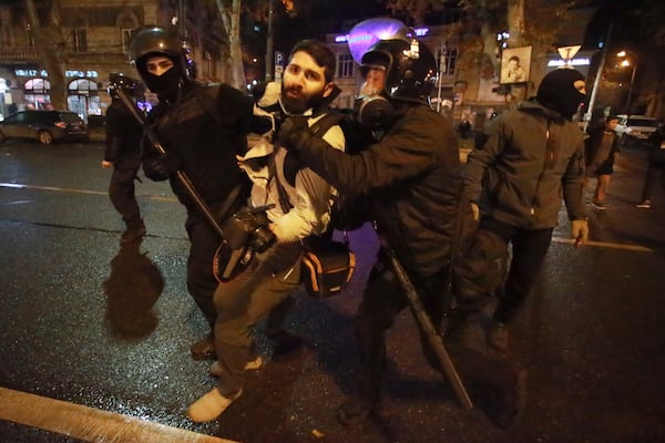 Police officers detain journalist Giorgi Chamelishvili during a rally against the government's decision to suspend negotiations on joining the European Union for four years, outside the parliament's building in Tbilisi, Georgia, early Monday, Dec. 2, 2024. (AP Photo/Zurab Tsertsvadze)