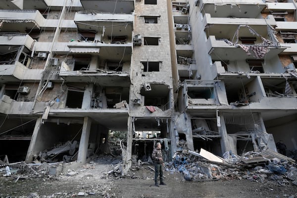 A man stands in front of a destroyed building after Sunday's Israeli airstrike in Dahiyeh, in the southern suburb of Beirut, Lebanon, Monday, Nov. 25, 2024. (AP Photo/Hussein Malla)