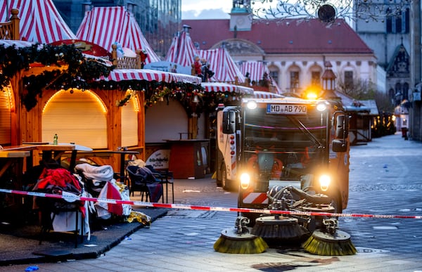 Public workers clean the Christmas Market, where a car drove into a crowd on Friday evening, in Magdeburg, Germany, on Sunday morning , Dec. 22, 2024. (AP Photo/Michael Probst)