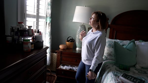 Susan Scarbro talks about her medication regimen while standing next to her collection of pills and supplements in her home in Sunset Beach, N.C. on Jan. 3, 2025. (AP Photo/Laura Bargfeld)