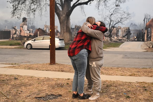 Lisa Diaz hugs a neighbor outside of their homes as the Eaton Fire sweeps through the area Wednesday, Jan. 8, 2025, in Altadena, Calif. (AP Photo/Nic Coury)