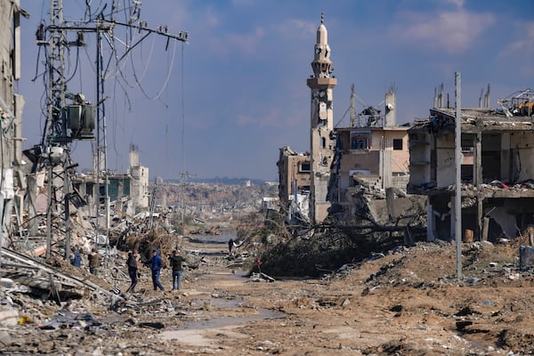 Palestinians walk past a mosque destroyed by the Israeli airstrikes in Nuseirat, Gaza Strip, Friday, Jan. 24, 2025, days after the ceasefire deal between Israel and Hamas came into effect. (AP Photo/Abdel Kareem Hana)