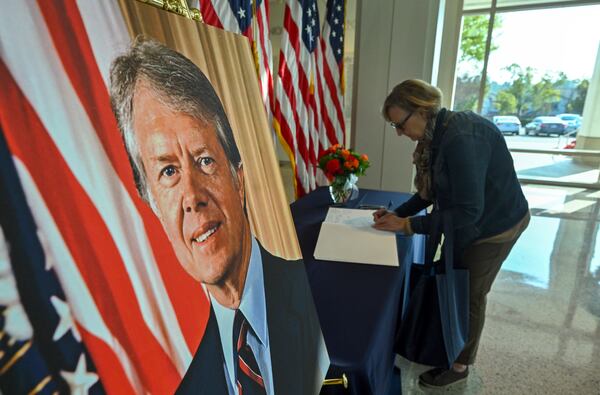 Chris Mapes, from Iowa, signs a condolence book for former President Jimmy Carter who died on Sunday, in the lobby of the The Richard Nixon Library & Museum in Yorba Linda, Calif., Monday, Dec. 30, 2024. (Jeff Gritchen/The Orange County Register via AP)