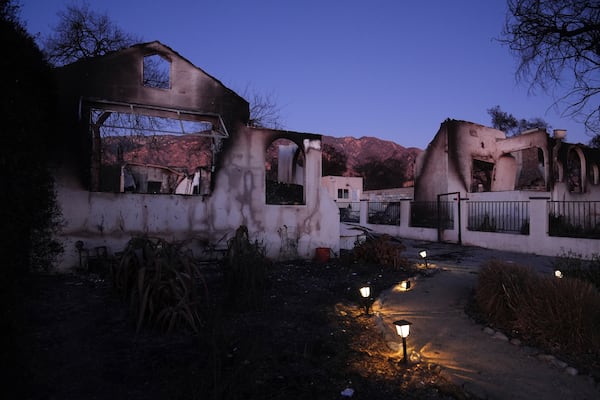 Solar lights remain on outside a home destroyed by the Eaton Fire, Tuesday, Jan. 14, 2025, in Altadena, Calif. (AP Photo/Jae C. Hong)