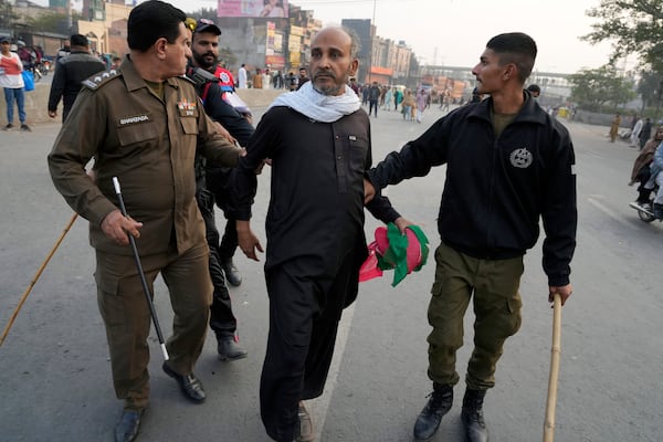 Police officers detain a supporter of imprisoned former premier Imran Khan's Pakistan Tehreek-e-Insaf party, which supporters gather for a rally demanding Khan's release, in Lahore, Pakistan, Sunday, Nov. 24, 2024. (AP Photo/K.M. Chaudary)