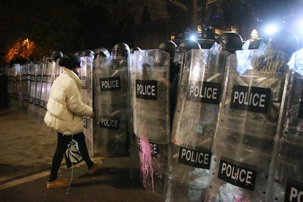 A woman speaks with police officers blocking a street to stop demonstrators protesting against the government's decision to suspend negotiations on joining the European Union in Tbilisi, Georgia, early Tuesday, Dec. 3, 2024. (AP Photo/Zurab Tsertsvadze)