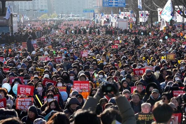 People attend at a rally to demand South Korean President Yoon Suk Yeol's impeachment outside the National Assembly in Seoul, South Korea, Saturday, Dec. 14, 2024. The letters read "Impeachment." (AP Photo/Lee Jin-man)