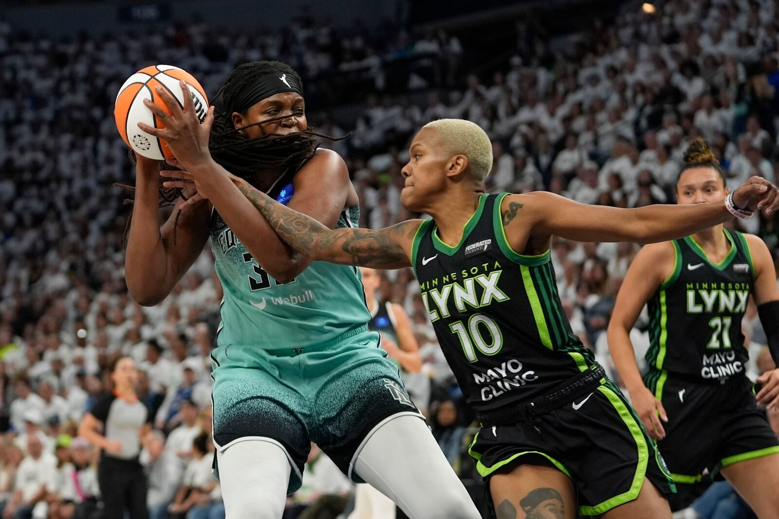 Minnesota Lynx guard Courtney Williams (10) reaches in against New York Liberty forward Jonquel Jones during the first half of Game 4 of a WNBA basketball final playoff series, Friday, Oct. 18, 2024, in Minneapolis. (AP Photo/Abbie Parr)