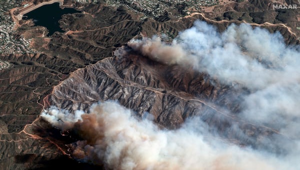 In this photo provide by Maxar Technologies, the Palisades Fire burns south of the Encino Reservoir, upper left, in Los Angeles, Saturday, Jan. 11, 2025. (Maxar Technologies via AP)