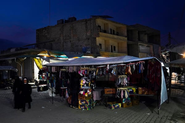 A street vendor displays clothing for sale in an open market in Atareb, northern the city of Aleppo, Syria, Sunday, Dec. 15, 2024. (AP Photo/Khalil Hamra)