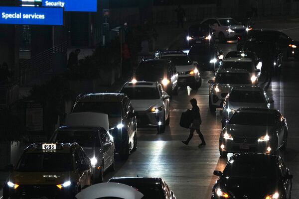 A traveler walks to Terminal 3 at O'Hare International Airport in Chicago, Tuesday, Nov. 26, 2024. (AP Photo/Nam Y. Huh)