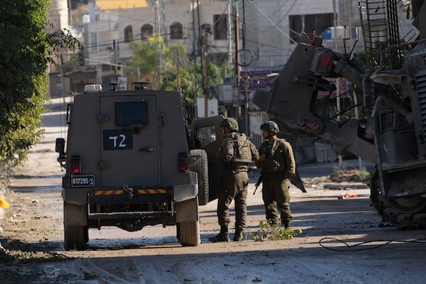 Members of Israeli forces patrol a street during a military operation in the Tulkarem refugee camp near the West Bank city of Tulkarem, Wednesday, Dec. 25, 2024. (AP Photo/Majdi Mohammed)