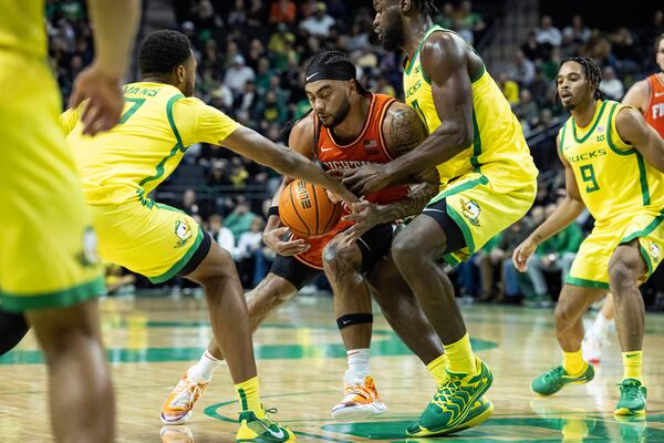 Illinois guard Kylan Boswell collides with Oregon forward Supreme Cook during the second half of an NCAA college basketball game in Eugene, Ore., Thursday, Jan. 2, 2025. (AP Photo/Thomas Boyd)