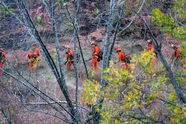 Inmate firefighters battling the Palisades Fire construct hand line to protect homes along Mandeville Canyon Rd. on Sunday, Jan. 12, 2025, in Los Angeles. (AP Photo/Noah Berger)