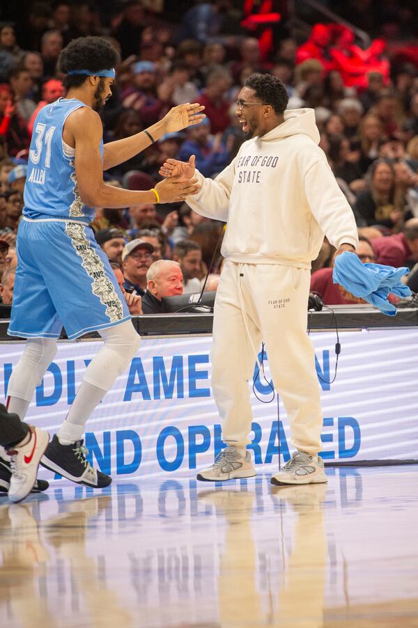 Cleveland Cavaliers' Jarrett Allen (31) is greeted by Donovan Mitchell, right, during the first half of an NBA basketball game against the Charlotte Hornets in Cleveland, Sunday, Nov 17, 2024. Mitchell did not play in the game. (AP Photo/Phil Long)