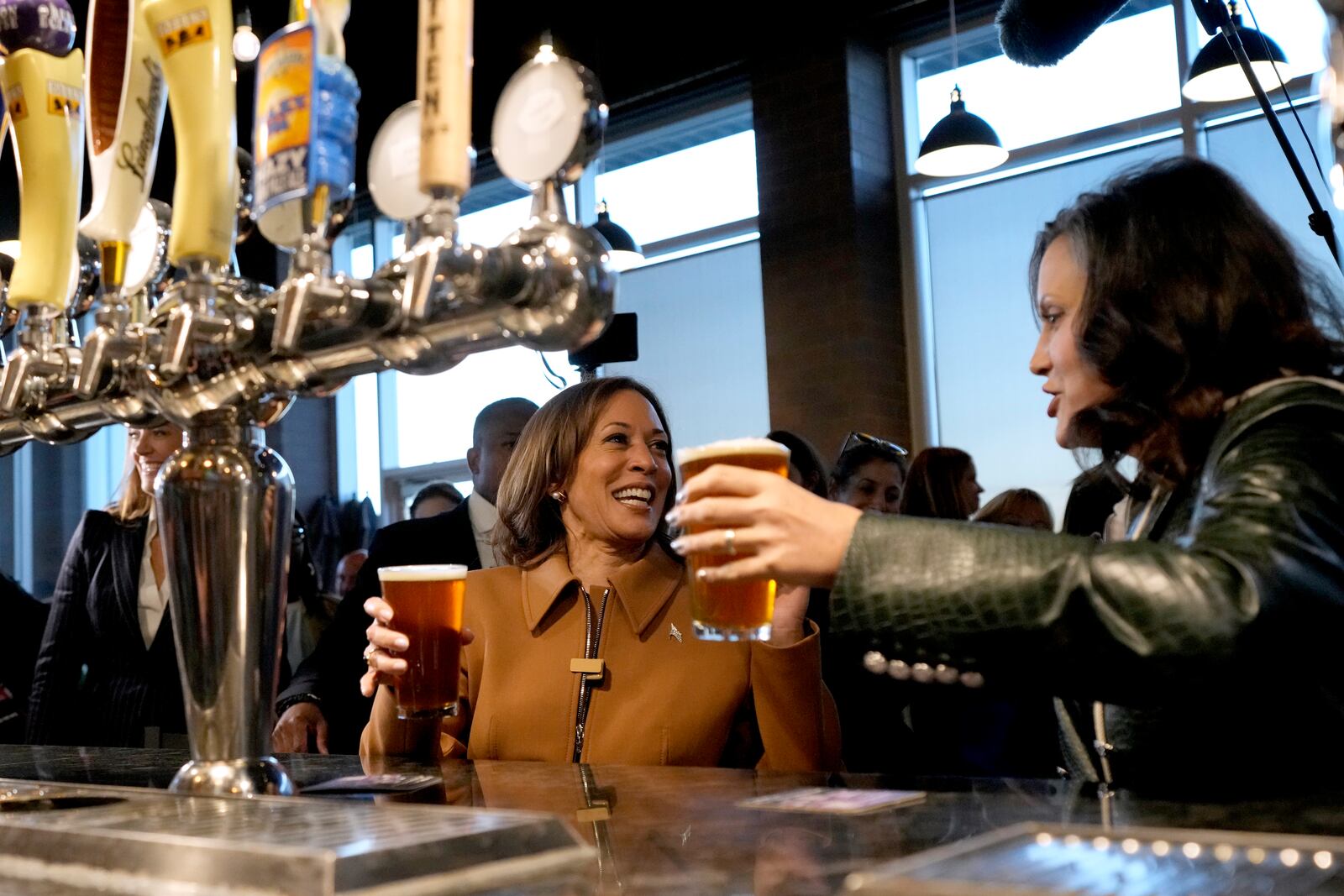 Democratic presidential nominee Vice President Kamala Harris, left, and Michigan Gov. Gretchen Whitmer hold beers while speaking at the Trak Houz Bar & Grill after a campaign rally in Kalamazoo, Mich. (AP Photo/Jacquelyn Martin)