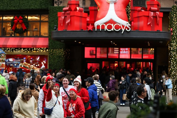 A group of shoppers take a selfie outside Macy's Herald Square, Friday, Nov. 29, 2024, in New York. (AP Photo/Heather Khalifa)